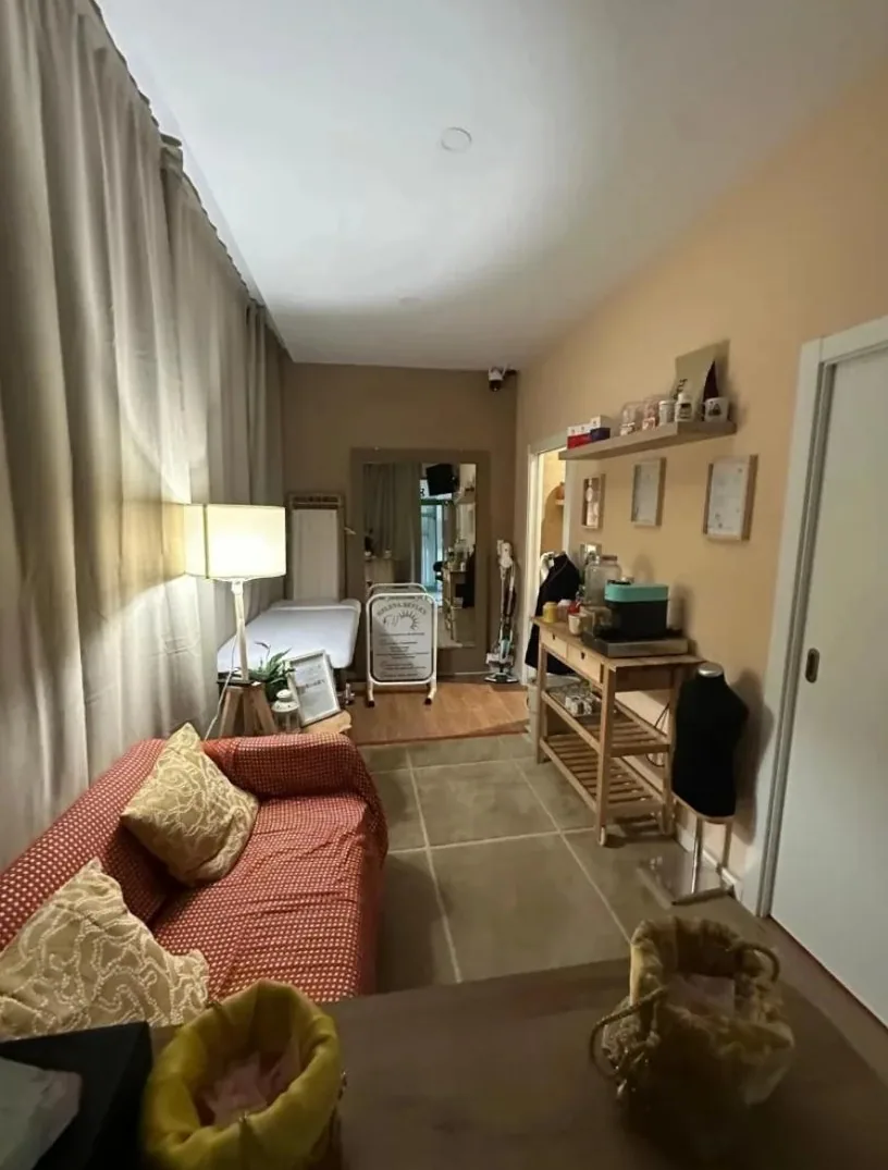 Sala de espera do centro, com sofá, candeeiro e a marquesa ao fundo